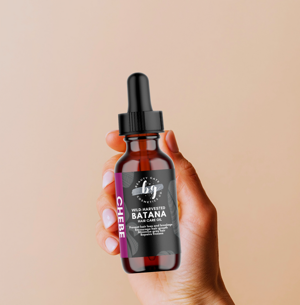 A hand holds a bottle of Wild-Harvested Batana Hair Care Oil.