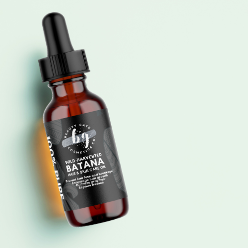 Brown glass bottle of Batana hair and skin care oil with black label and dropper on a light green background.