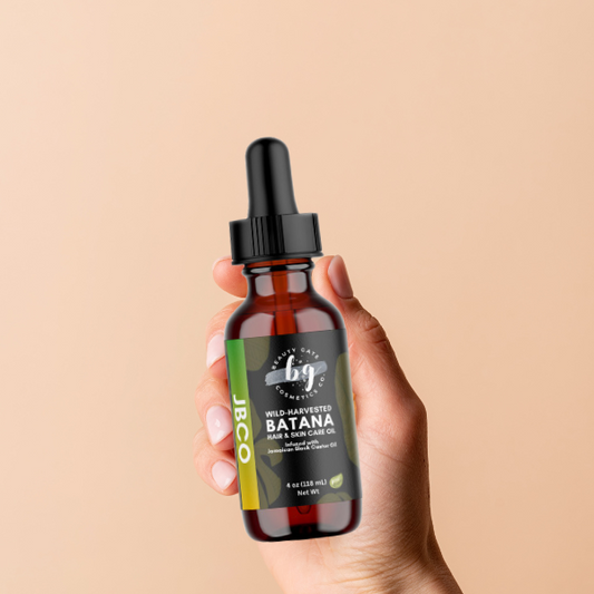 Hand holding a bottle of "Wild-Harvested Batana Hair & Skin Care Oil."