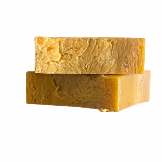 Two rectangular bars of yellow, textured soap stacked on top of each other.
