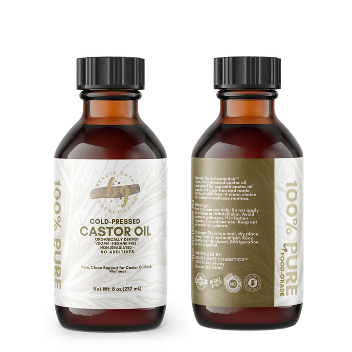 Two amber glass bottles of cold-pressed castor oil, one showing the front label and the other showing the back.