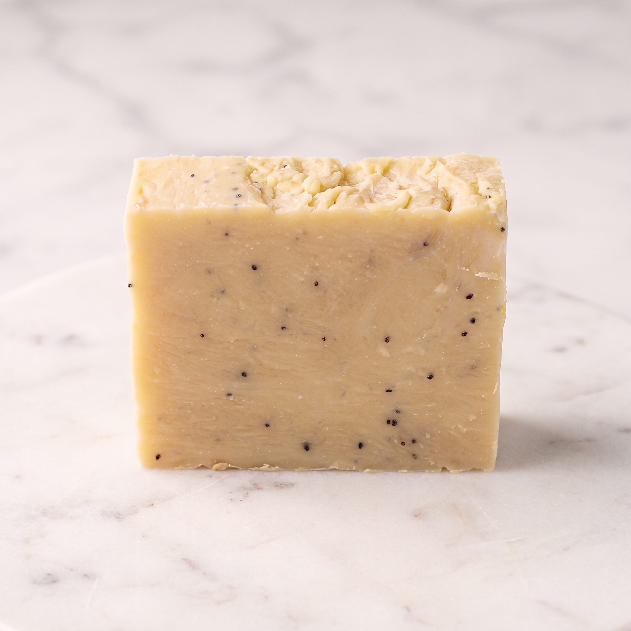 Sweet Berry Exfoliating Face & Body Soap Bar - professional hero shot, creamy butter-yellow with poppy seeds, no label