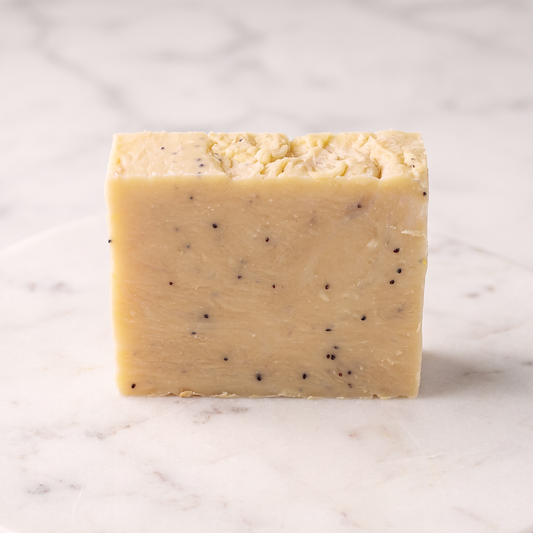 Sweet Berry Exfoliating Face & Body Soap Bar - professional hero shot, creamy butter-yellow with poppy seeds, no label